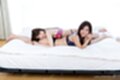 Girls lying on bed together in underwear